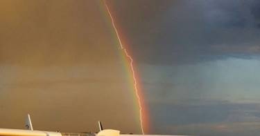 Такие снимки получаются раз на миллион: фотограф захватил молнию, рассекающую радугу.